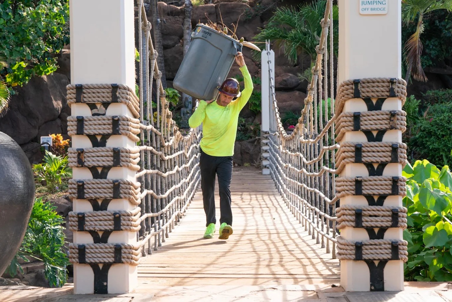 Coconut Kuleana crew member hauling palm debris during immaculate clean-up service at Maui resort