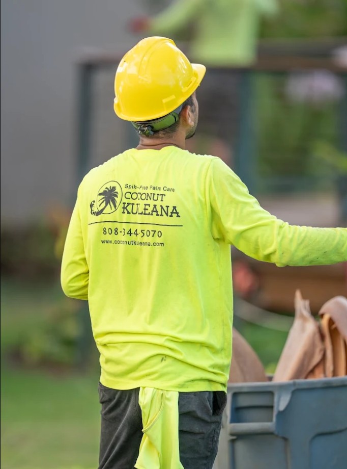 Coconut Kuleana spike-free palm care uniform showing company logo phone number and website Maui Hawaii